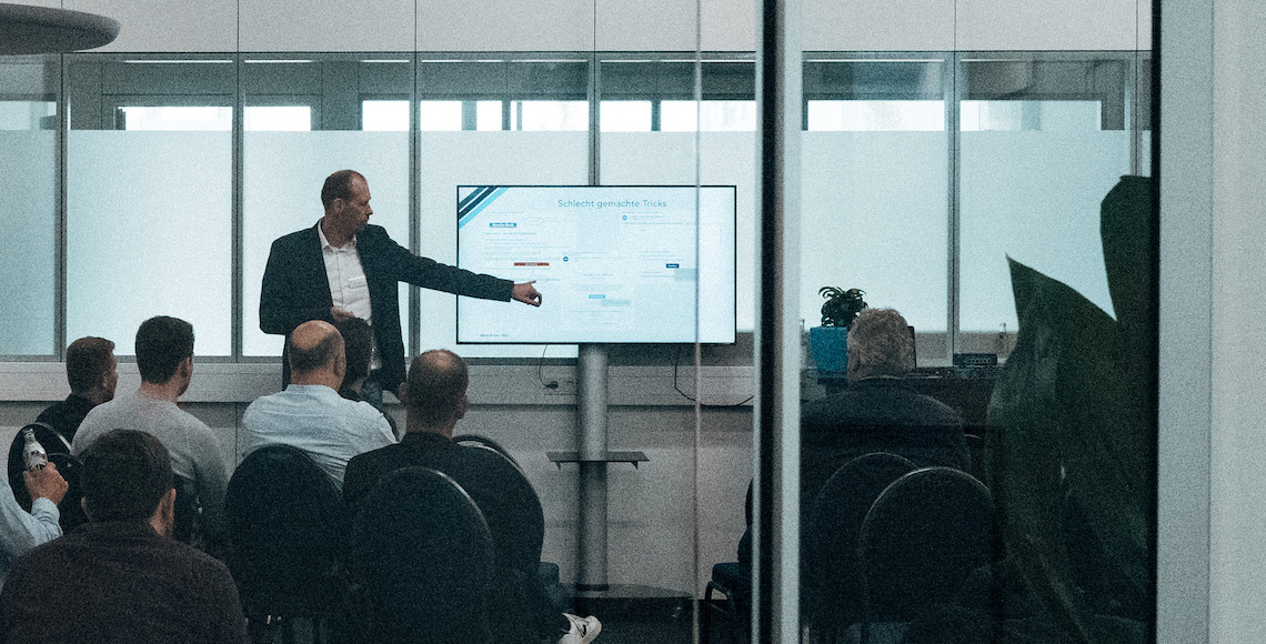 Ein Mitarbeiter von Anqa IT-Security erklärt etwas auf einem Bildschirm bei einer Security Awareness Schulung